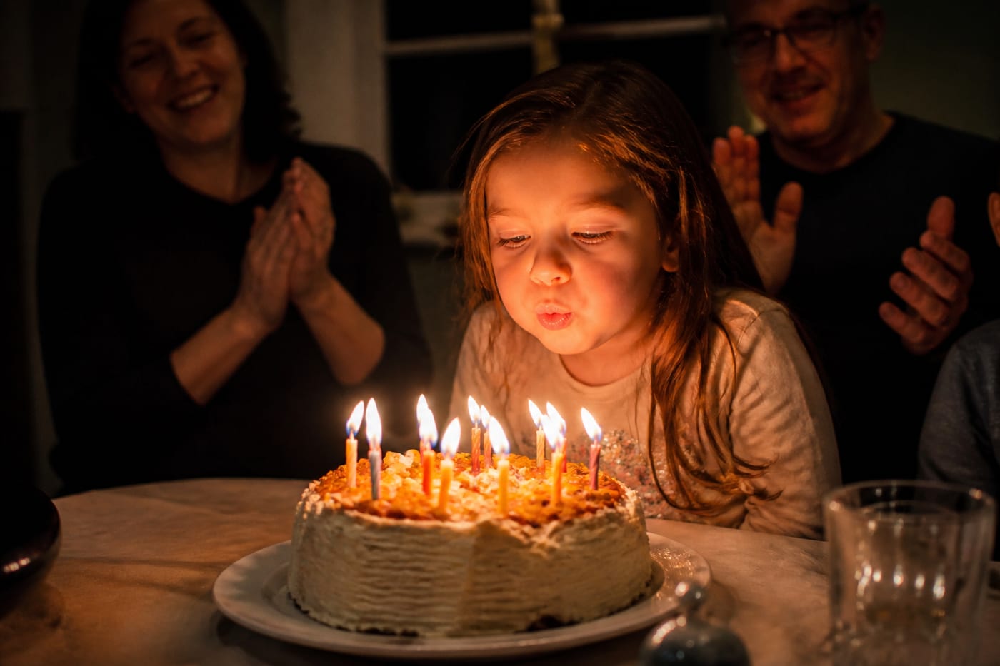 Niña soplando las velas de cumpleaños